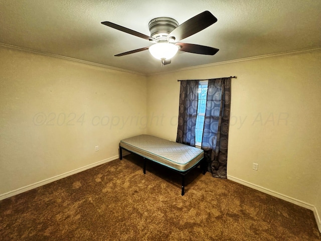 unfurnished bedroom featuring a textured ceiling, dark carpet, ceiling fan, and ornamental molding