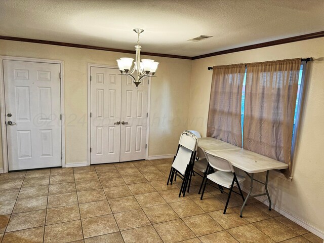 tiled dining space featuring crown molding, a textured ceiling, and a chandelier