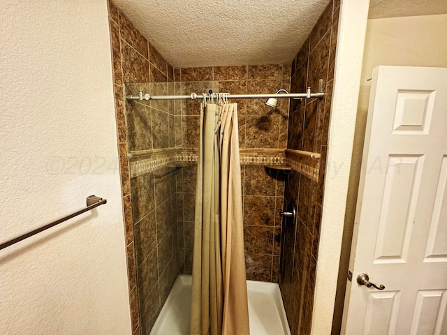 bathroom with a textured ceiling and a shower with shower curtain