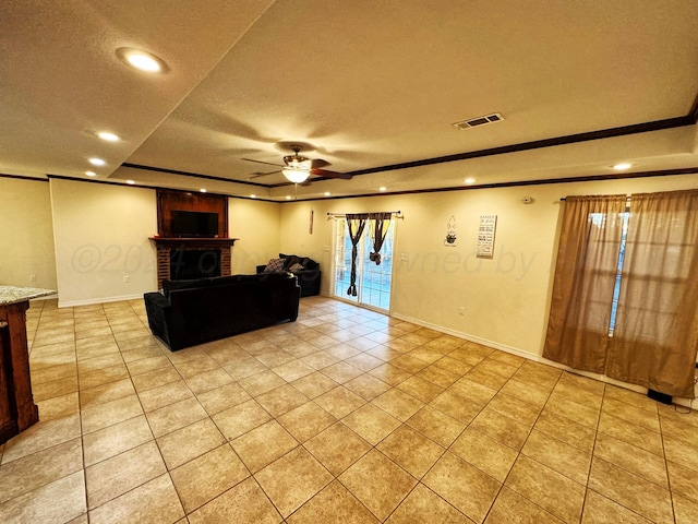 tiled living room featuring a raised ceiling, a textured ceiling, a brick fireplace, and ceiling fan