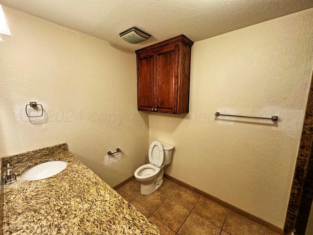 bathroom with tile patterned floors, sink, a textured ceiling, and toilet