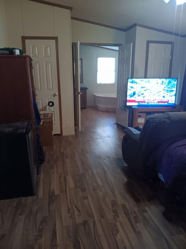 hallway featuring crown molding, dark hardwood / wood-style flooring, and vaulted ceiling