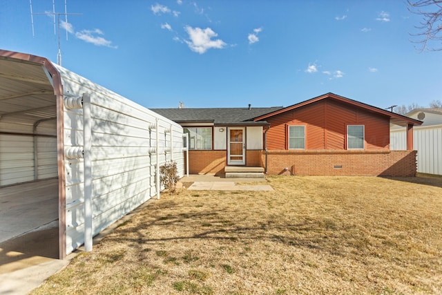 rear view of house featuring a lawn and a carport