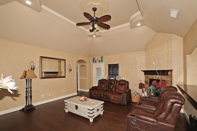 living room featuring arched walkways, a fireplace, wood finished floors, visible vents, and baseboards