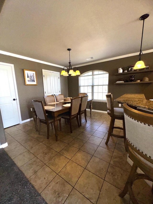 dining area with visible vents, baseboards, ornamental molding, dark tile patterned floors, and a notable chandelier