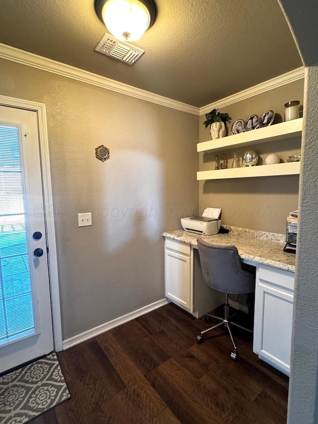 home office with dark wood-style floors, visible vents, ornamental molding, built in study area, and a textured ceiling