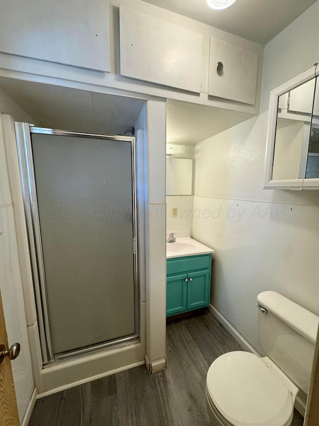 bathroom with vanity, wood-type flooring, a shower with shower door, and toilet