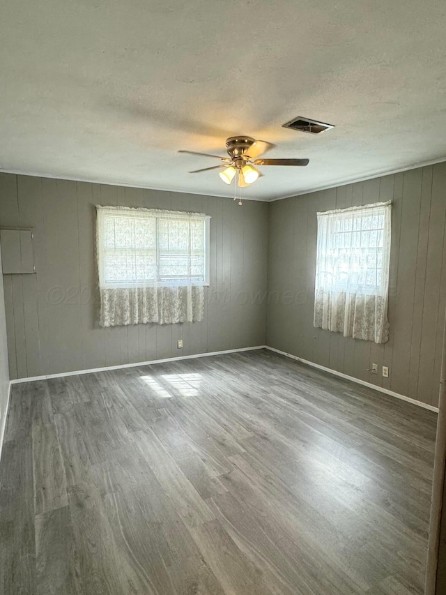 empty room featuring hardwood / wood-style floors, a wealth of natural light, and ceiling fan