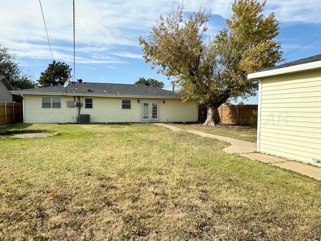 back of property with a lawn, central air condition unit, and french doors