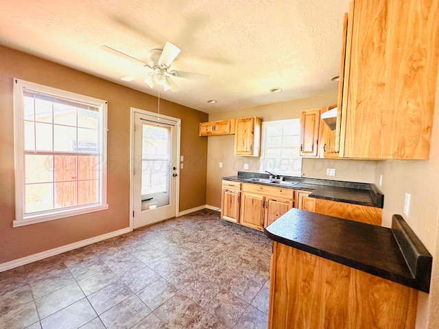 1521 Fox Ave, Dumas, TX 79029 - kitchen featuring dark countertops, ceiling fan, and a textured ceiling