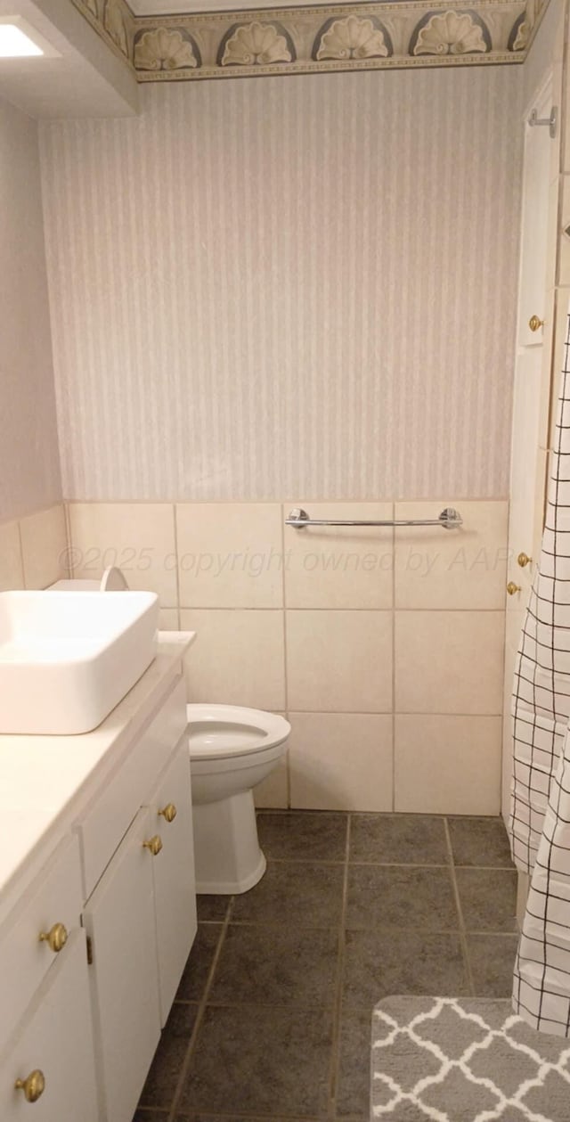 706 Mills Ave, Dumas, TX 79029 - bathroom featuring vanity, tile patterned floors, and tile walls