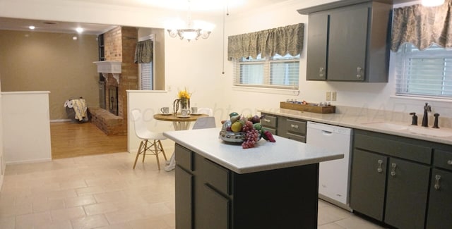 706 Mills Ave, Dumas, TX 79029 - kitchen featuring white dishwasher, a kitchen island, light countertops, a chandelier, and decorative light fixtures