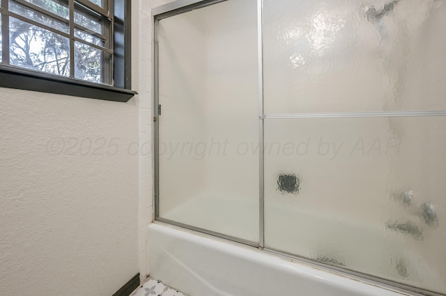 bathroom featuring bath / shower combo with glass door