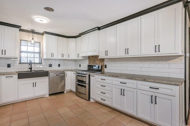 kitchen with pendant lighting, sink, appliances with stainless steel finishes, backsplash, and white cabinets