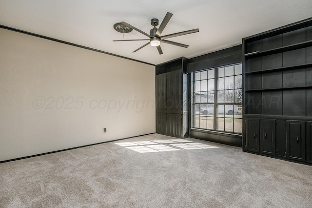 empty room featuring crown molding, light carpet, and ceiling fan