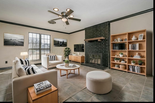 living room with ornamental molding, ceiling fan, a fireplace, and dark tile patterned flooring