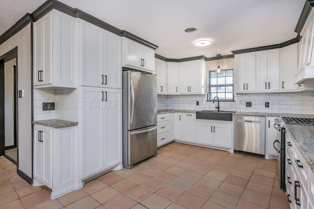 kitchen featuring sink, white cabinetry, hanging light fixtures, stainless steel appliances, and decorative backsplash