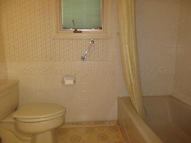 7503 Baughman Dr, Amarillo, TX 79121 - full bathroom with shower / bath combo and tile walls