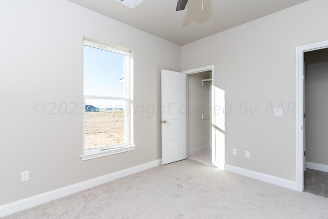 unfurnished bedroom featuring carpet, baseboards, and ceiling fan