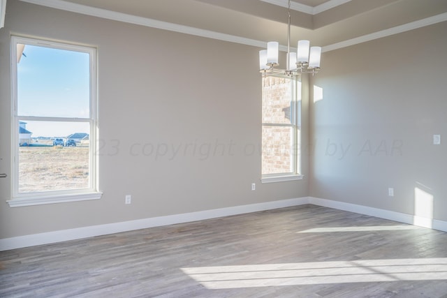 spare room with crown molding, baseboards, and wood finished floors