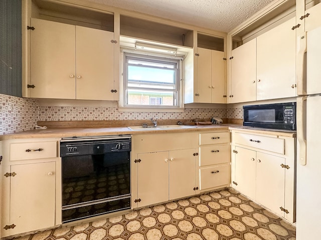 1705 Takewell St, Borger, TX 79007 - kitchen with black appliances, a sink, light countertops, tasteful backsplash, and a textured ceiling