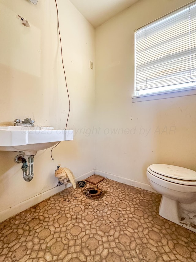 1705 Takewell St, Borger, TX 79007 - bathroom featuring toilet, stone finish floors, and baseboards
