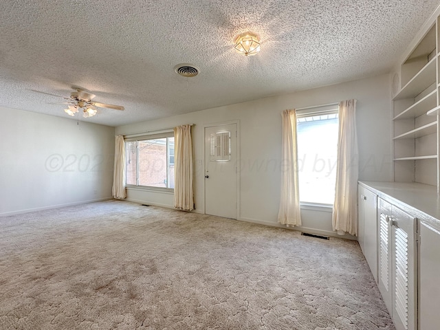 1705 Takewell St, Borger, TX 79007 - unfurnished living room with ceiling fan, light carpet, and a textured ceiling