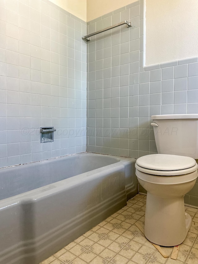 1705 Takewell St, Borger, TX 79007 - bathroom featuring tile walls, toilet, tile patterned floors, and bathtub / shower combination