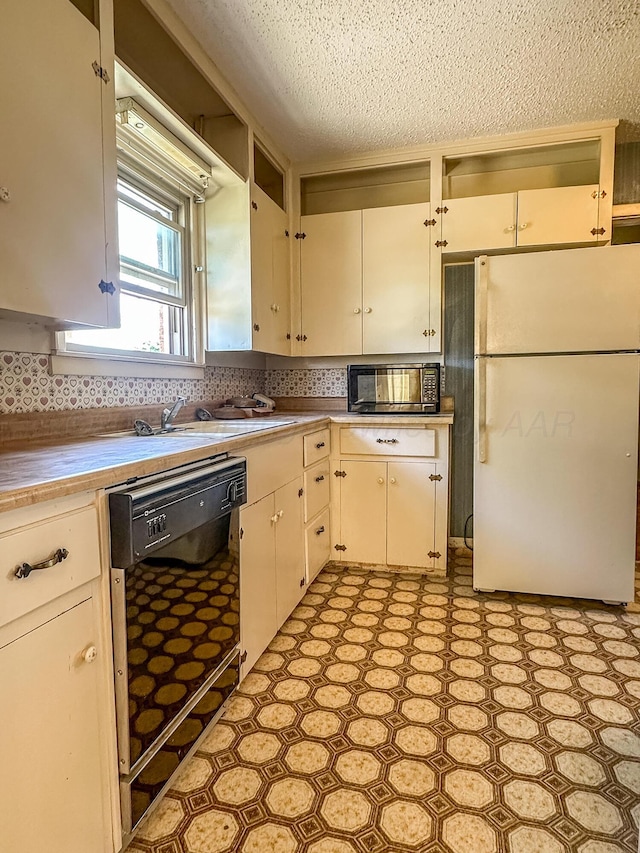 1705 Takewell St, Borger, TX 79007 - kitchen featuring black appliances, light flooring, a textured ceiling, light countertops, and backsplash