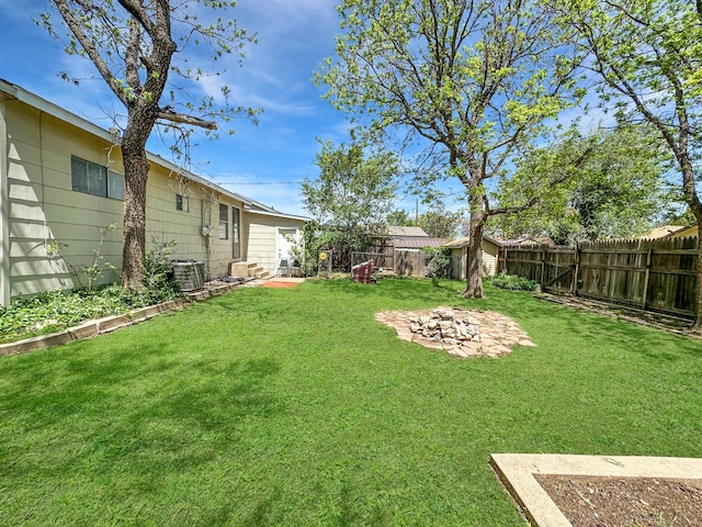 view of yard with central air condition unit, a fenced backyard, and a patio area
