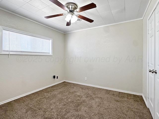 spare room with baseboards, ornamental molding, carpet, and a ceiling fan