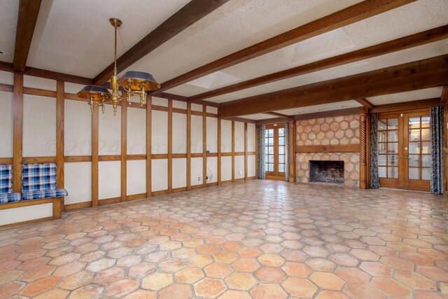 4321 Emil Ave, Amarillo, TX 79106 - unfurnished living room featuring beamed ceiling, a chandelier, and a large fireplace