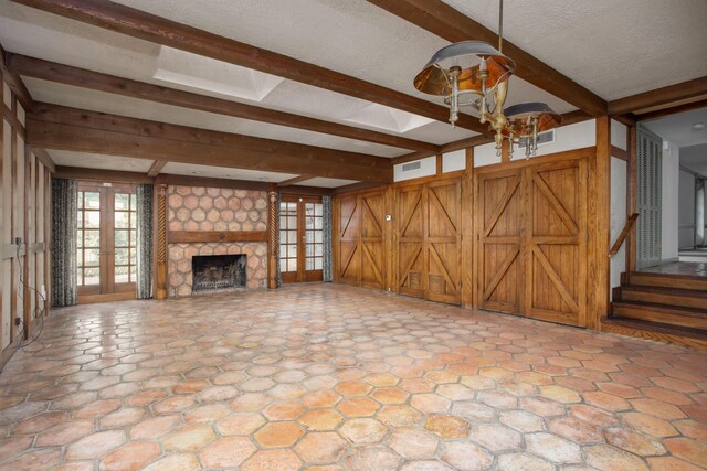 4321 Emil Ave, Amarillo, TX 79106 - unfurnished living room featuring beamed ceiling, a stone fireplace, and a chandelier