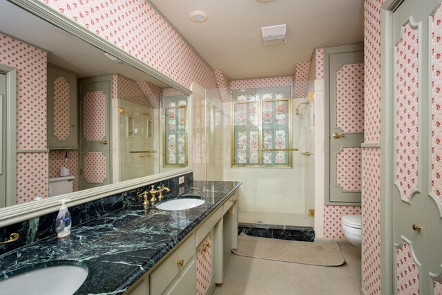 4321 Emil Ave, Amarillo, TX 79106 - bathroom featuring toilet, a shower stall, double vanity, tile patterned flooring, and wallpapered walls