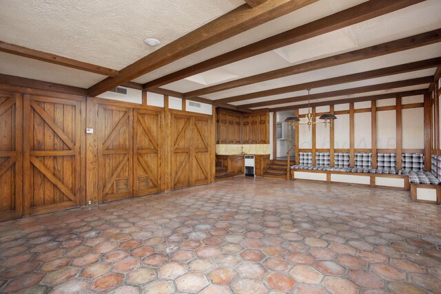 4321 Emil Ave, Amarillo, TX 79106 - unfurnished living room featuring beam ceiling and wood walls