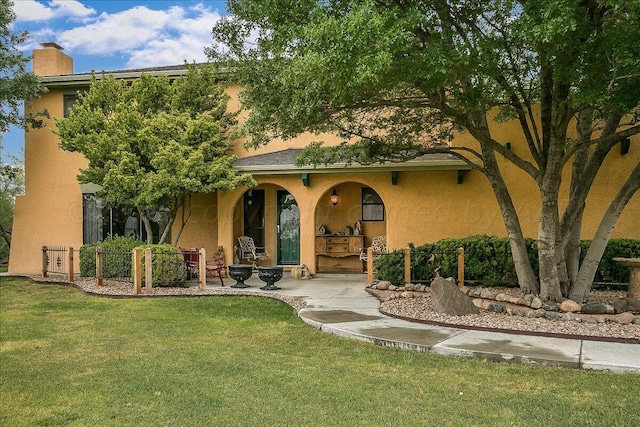 view of front of property featuring a front lawn and a patio area