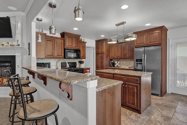 905 Red Deer Ln, White Deer, TX 79097 - kitchen with black appliances, a peninsula, backsplash, a kitchen island, and a breakfast bar
