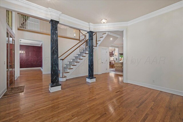 3511 Kensington Pl, Amarillo, TX 79121 - empty room featuring wood finished floors, baseboards, stairway, crown molding, and ornate columns