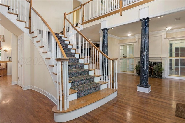 3511 Kensington Pl, Amarillo, TX 79121 - stairway featuring decorative columns, wood finished floors, ornamental molding, baseboards, and a towering ceiling