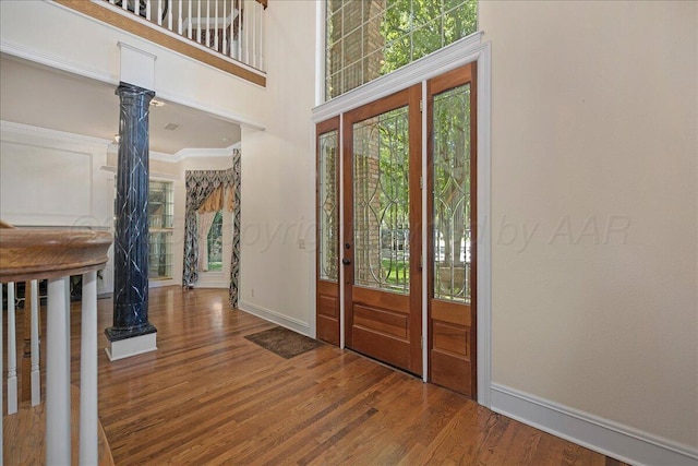 3511 Kensington Pl, Amarillo, TX 79121 - foyer entrance featuring baseboards, ornate columns, wood finished floors, and ornamental molding