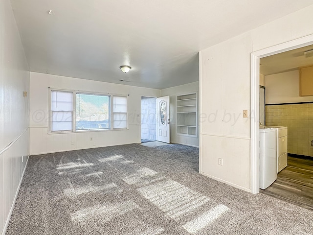 spare room featuring built in shelves, carpet floors, and independent washer and dryer