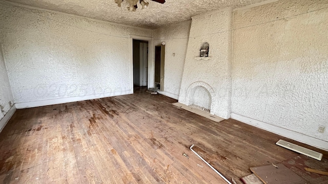 spare room featuring baseboards, ceiling fan, and wood finished floors