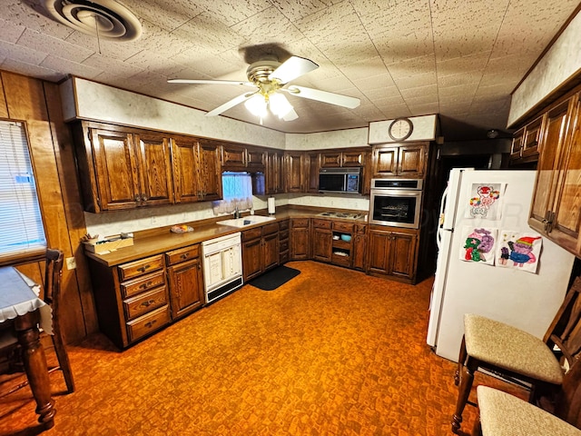 kitchen with white appliances, a ceiling fan, and a sink