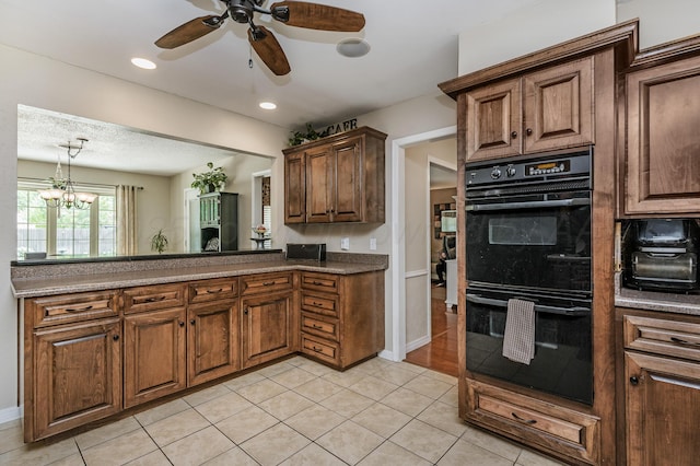 8615 Olympia Dr, Amarillo, TX 79110 - kitchen with ceiling fan, light tile patterned floors, baseboards, dark countertops, and hanging light fixtures