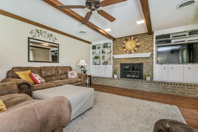 8615 Olympia Dr, Amarillo, TX 79110 - living area with wood finished floors, beamed ceiling, ceiling fan, a textured ceiling, and a fireplace