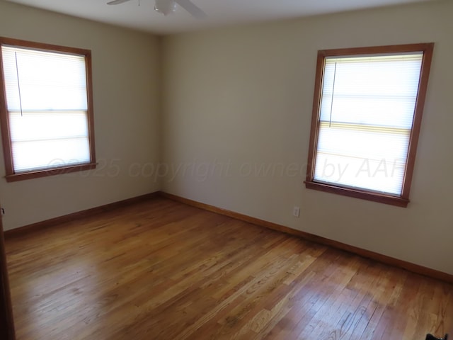 unfurnished room featuring plenty of natural light, light wood finished floors, ceiling fan, and baseboards