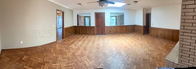 6201 Adirondack Trl, Amarillo, TX 79106 - empty room with wainscoting, a ceiling fan, wood walls, and a skylight