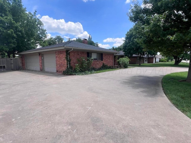 6201 Adirondack Trl, Amarillo, TX 79106 - view of property exterior with curved driveway, brick siding, a chimney, and an attached garage