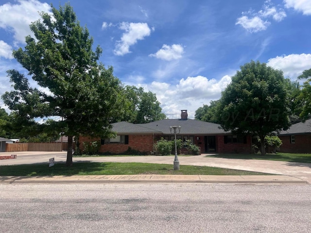 6201 Adirondack Trl, Amarillo, TX 79106 - ranch-style home with brick siding, a chimney, and curved driveway