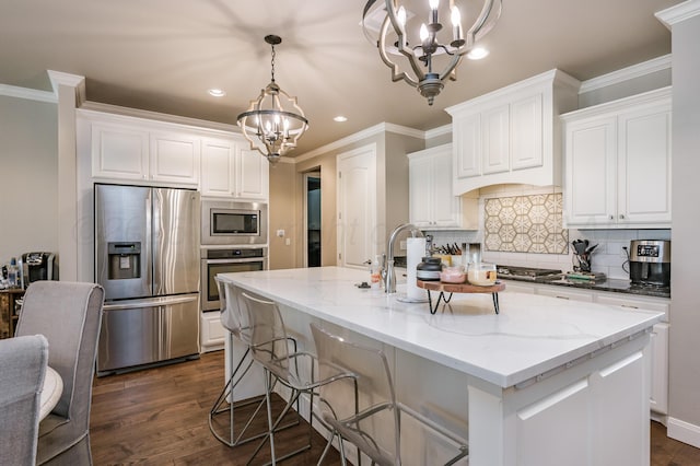 kitchen featuring a kitchen island with sink, appliances with stainless steel finishes, and an inviting chandelier